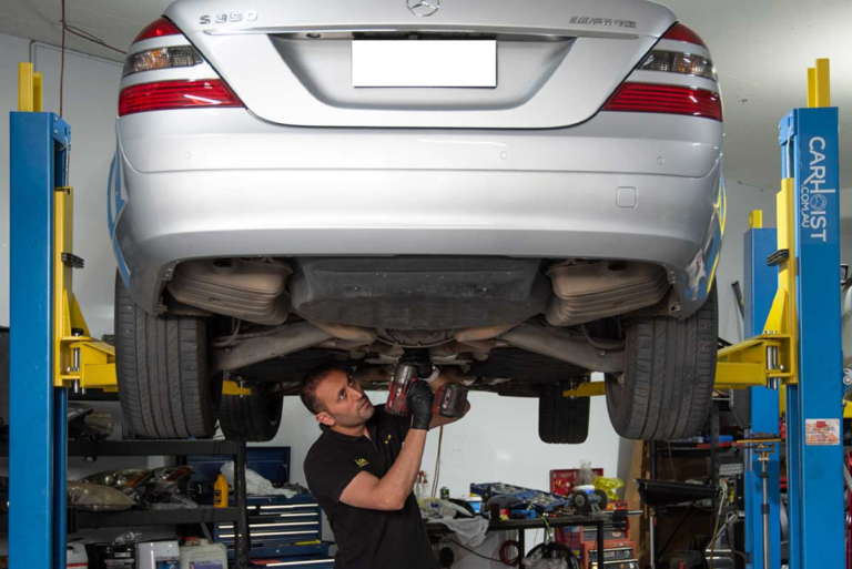 Mechanic servicing Mercedes-Benz underbody